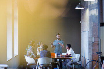 Lens flare over creative business people meeting at office table