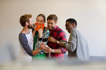 Smiling casual business people looking at instant photos