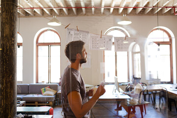 Creative businessman brainstorming with hanging diagrams