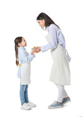 Young mother and daughter with tasty dish in saucepot on white background