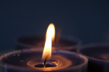 Burning candles.Candle flame.Set candles in the dark.Religion symbol. Candles background.Blue candles on dark blue background. 