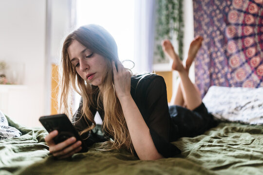 Woman in bed with smartphone