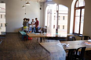 Casual business people joining hands in meeting in office