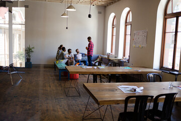 Creative business people talking in circle in office