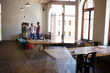 Creative business people talking in circle in office