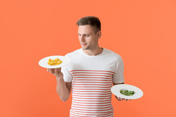 Handsome young man with plates of different tasty ravioli on color background
