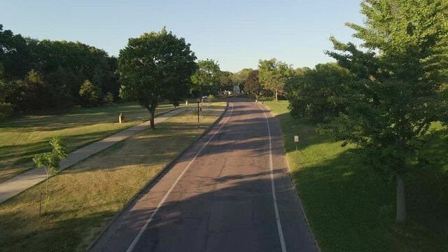 wonderful neighborhood in the suburbs Minneapolis during a summer calm afternoon, people biking and cars passing by