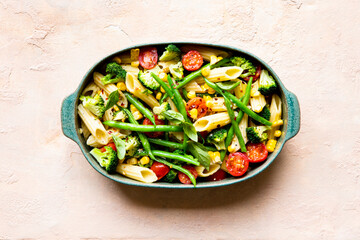 Penne pasta  salad with broccoli, green beans, corn, vegetables and tomato