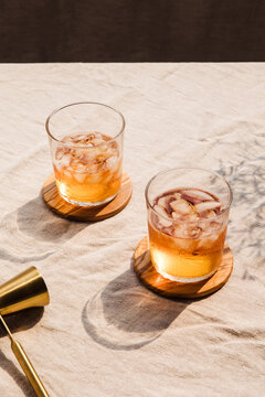 Pair of iced dark liquor glasses and a golden double jigger