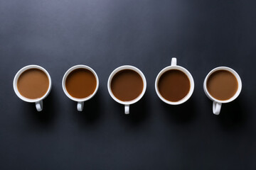 Cups of tasty coffee on dark background