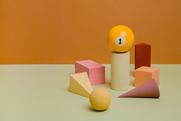 Different wooden forms with billiard ball on paper background