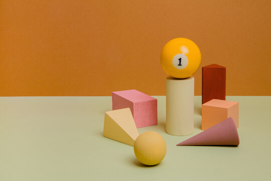 Different wooden forms with billiard ball on paper background