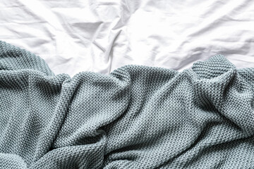 Knitted plaid on bed, closeup