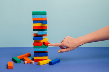 Tower of colorful blocks on blue paper background 