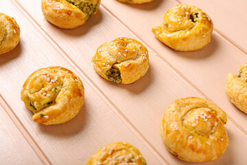Puff pastry stuffed with spinach on color wooden background
