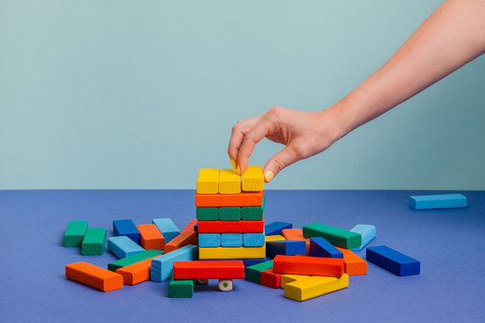 Destroyed tower of colorful blocks on blue paper background 
