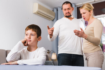 Obraz premium Portrait of upset boy scolded by parents at home