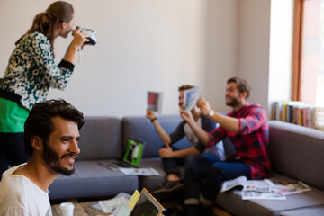 Creative business people playfully posing for coworker instant camera