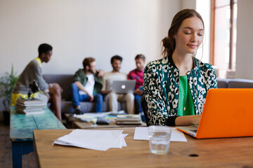 Smiling creative businesswomen working at laptop in office