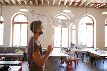 Creative businessman brainstorming with hanging diagrams