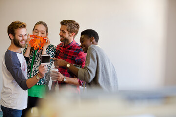 Smiling casual business people looking at instant photos