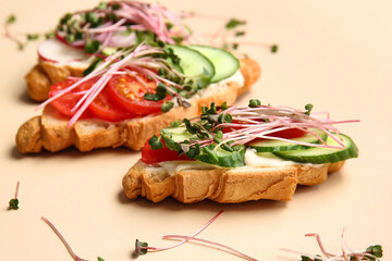 Tasty croissants with vegetables and micro green on color background