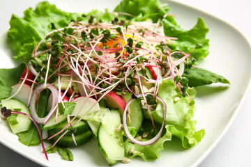 Plate of tasty salad with vegetables, fried egg and micro green on light background, closeup