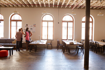 Creative business people talking in circle in office