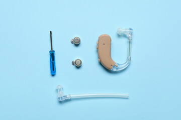 Hearing aid with accessories on color background