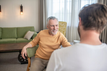 Obraz premium Two men sitting at the table, having tea and talking