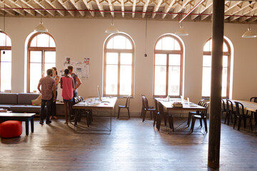 Creative business people talking in circle in office