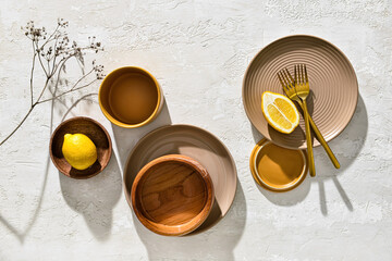 Different tableware and lemon on white background