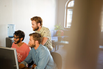 Obraz premium Focused casual businessmen working at computer in sunny office