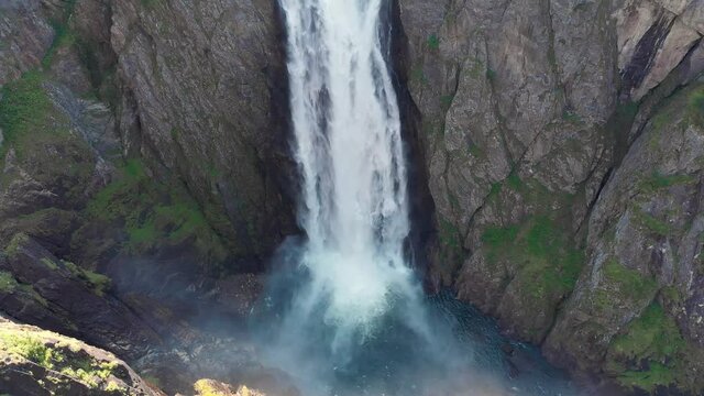 Bottom of falls as water crash into plunge pool; aerial dolly right