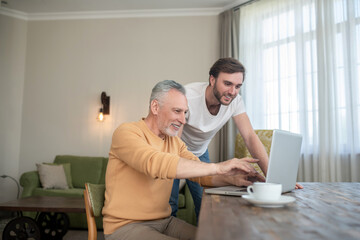 Obraz premium Two men in the room at the laptop watching something on a laptop