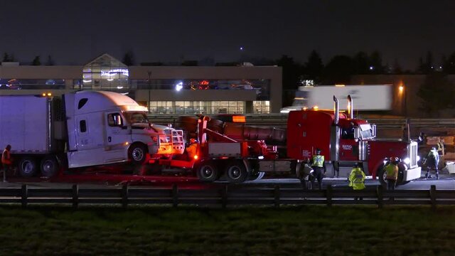 Heavy Duty Truck Towing A Trailer Truck Stucked On The Road At Night. wide shot