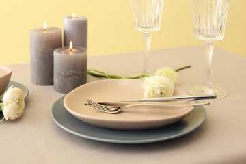Stylish table setting and ranunculus flower on color background