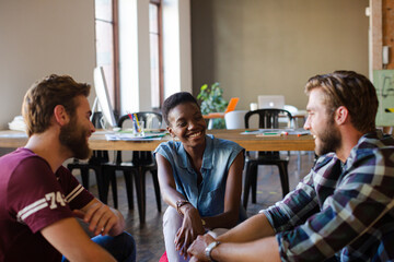 Casual business people meeting in circle in sunny office