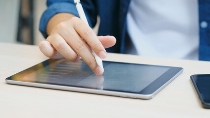 Close up of man hand using digital tablet for working at home, online study, telecommunication
