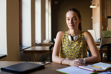 Portrait smiling casual businesswoman headphones in sunny open office