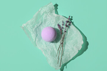 Bath bomb and lavender flowers on color background