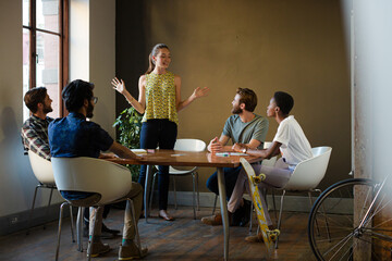 Casual business people meeting in circle in sunny office