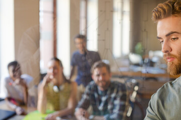 Casual businessman explaining diagram on glass in meeting