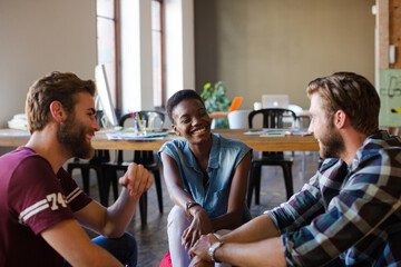 Casual business people meeting in circle in sunny office