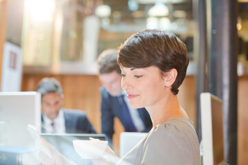 Smiling businesswoman drinking coffee in office