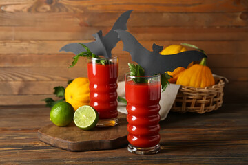 Glasses of tasty bloody Mary cocktail decorated for Halloween on wooden background
