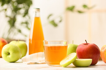 Glass of apple juice and fresh fruits on table