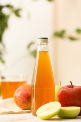 Bottle of apple juice and fresh fruits on table