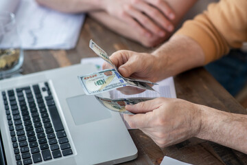 Close up picture of mans hands counting money