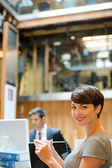 Fototapeta na wymiar Smiling businesswoman drinking coffee in office